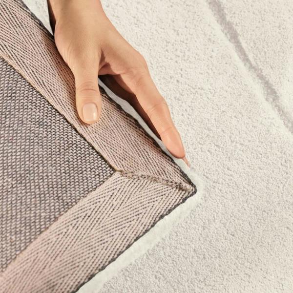 Hand touching the edge of a textured fabric surface