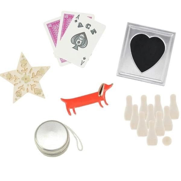 Contents and premium keepsake gifts from inside the Pearl Bow Christmas Crackers including an enamel sausage dog pin, magic card trick, and mini skittles.