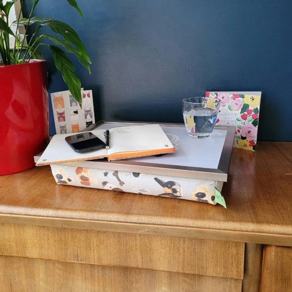 Portrait Pups lap tray on a wooden table with a glass of water, a book and a phone resting on it