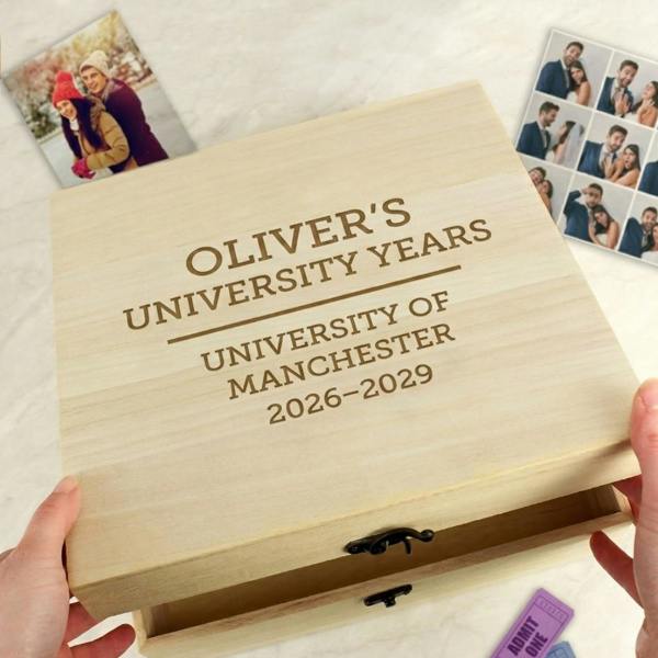 Personalised wooden university keepsake box engraved with 'OLIVER'S UNIVERSITY YEARS, UNIVERSITY OF MANCHESTER, 2026-2029' held by hands opening the lid.