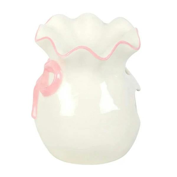 White oil burner with pink bow and scalloped top, side view