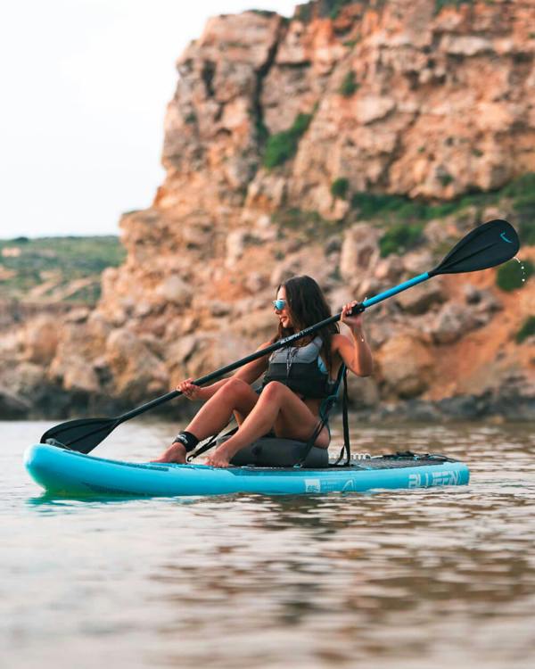 lady sat on a Bluefin blue gecko cruise 10'8 inflatable paddle board with seat on Malta ocean water 