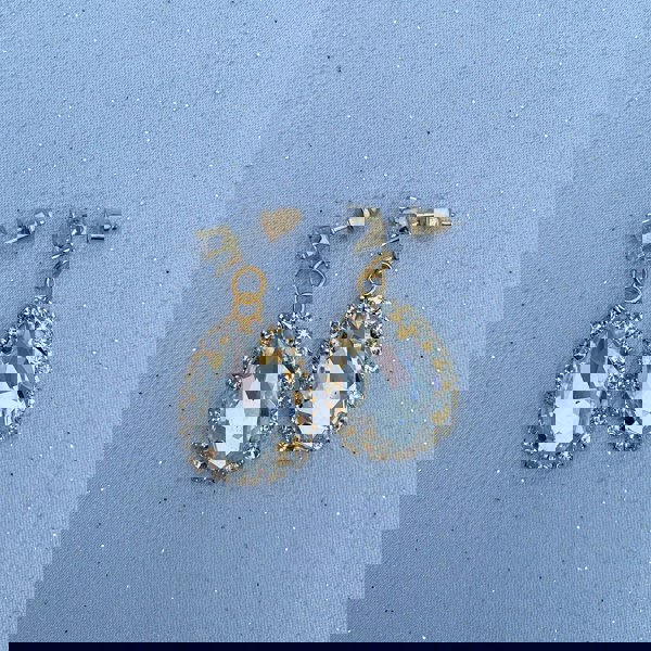 Drop earrings, large teardrop-shaped clear crystals, surrounded by sparkling diamante halo, gold-tone setting, vintage inspired design, elegant statement jewellery
