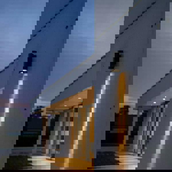 black exterior wall downlight mounted on a concrete wall on the exterior of a modern home 