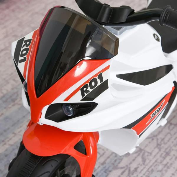 Close-up of a white and red 3-wheel ride-on police bike with front headlight lens