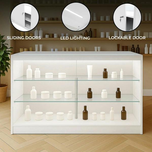 White LED retail shop counter K1500 with sliding doors, lockable features, and glass shelves displaying various cosmetic containers