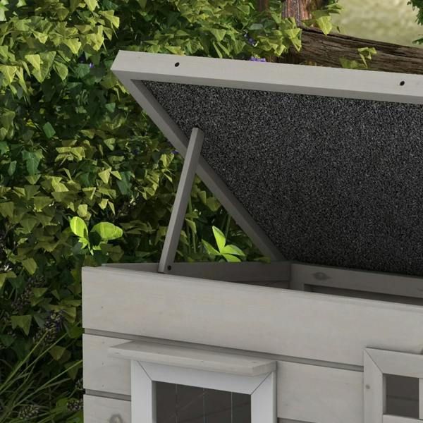 Close view of grey wooden cat house open roof frame and dark asphalt panel