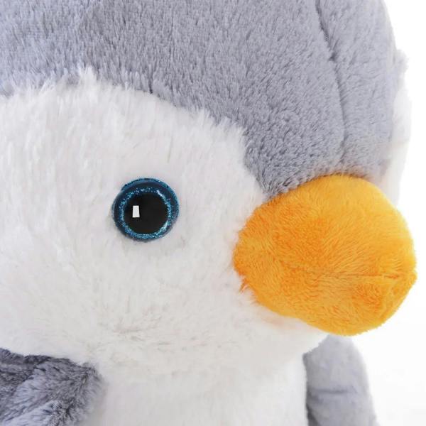 Close-up plush penguin face with orange beak and blue embroidered eye on gray fabric