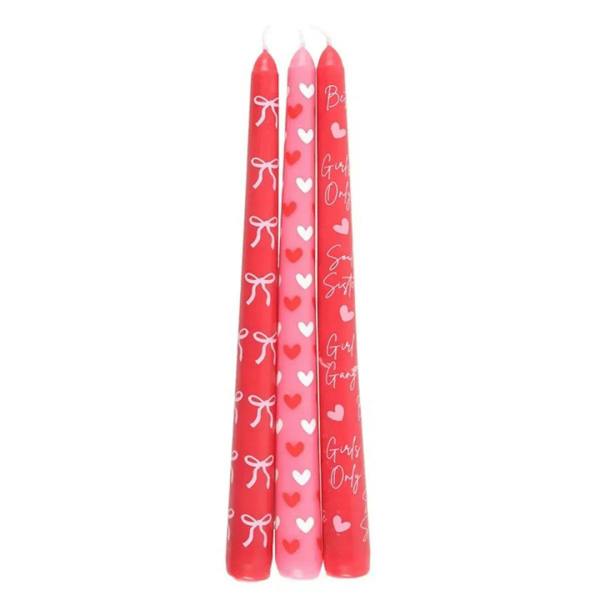 Three tall taper candles, red and pink with hearts and bow designs