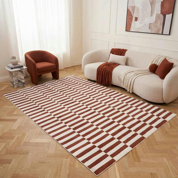 Living room with a striped rug, sofa, and armchair.