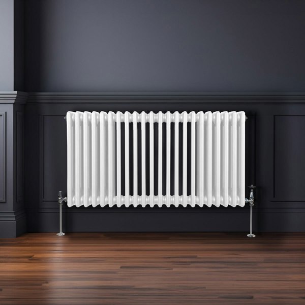 Traditional 3 column radiator in white, featuring a sleek design with vertical fins, mounted on a dark wall above wooden flooring