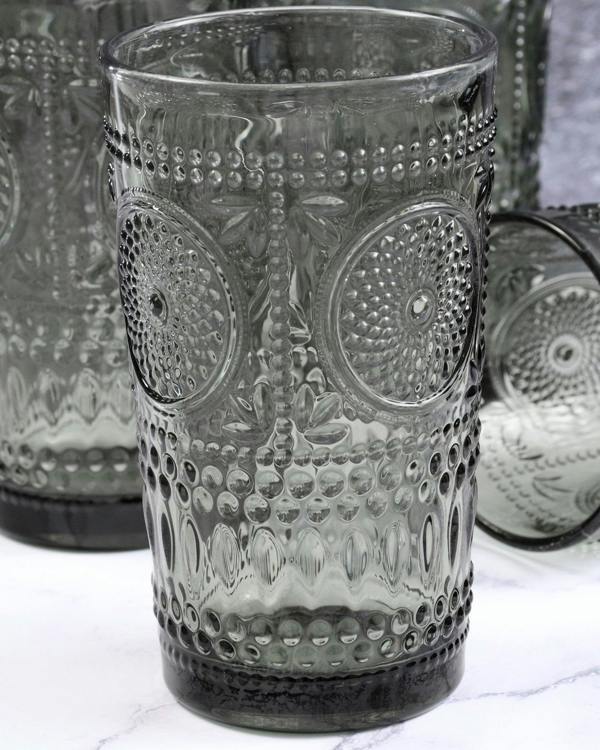 Decorative glass tumbler with textured design on a white surface