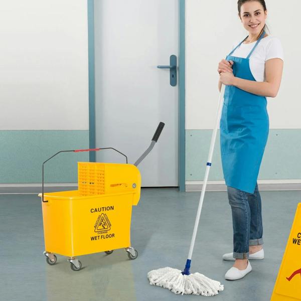 Yellow mop bucket on wheels near a standing cleaner, caution wet floor label and handle