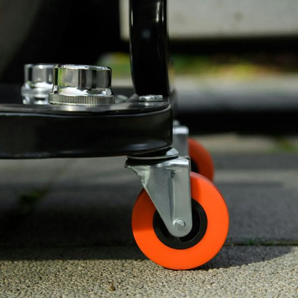 Orange caster wheel under black rolling stool frame for smooth workshop mobility