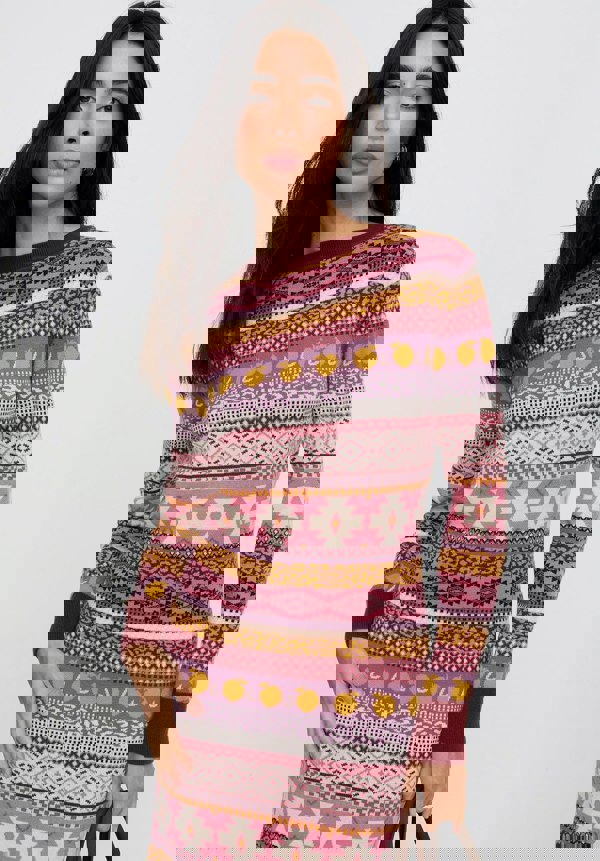 Woman wearing a colorful patterned sweater dress on a white background