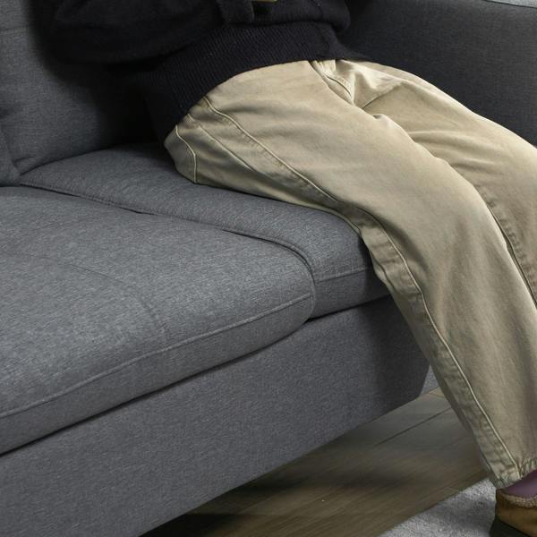 Dark grey sofa seat and armrest with a beige throw cushion on top
