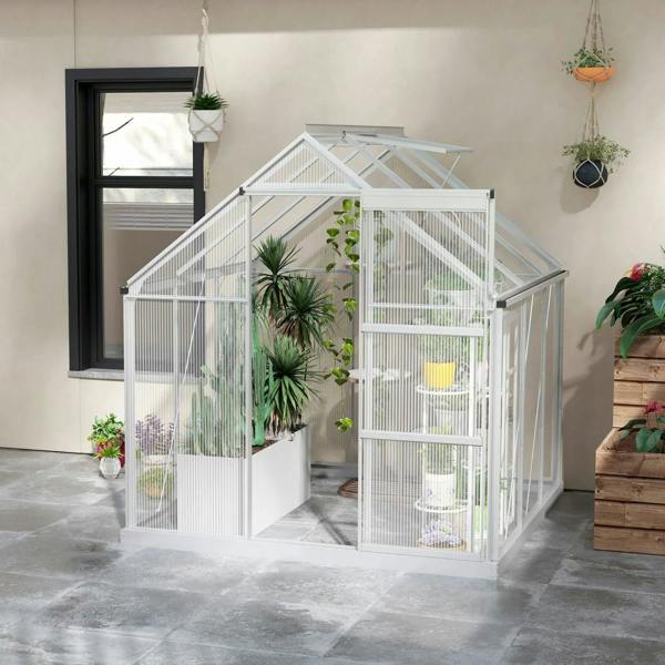 Walk-in greenhouse with clear polycarbonate walls, sliding door, and peaked roof