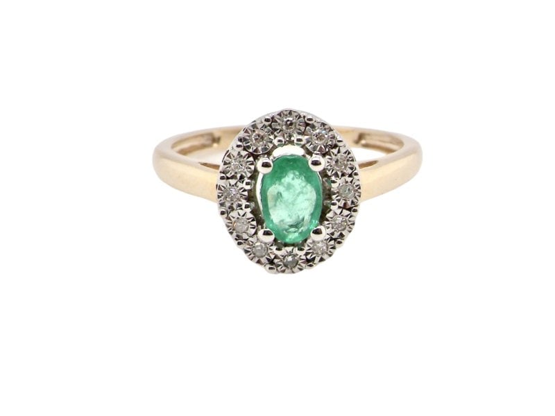 An emerald and diamond cluster ring