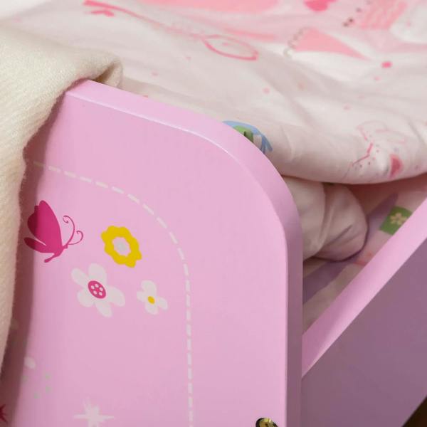 Close-up of pink end panel with castle graphic and safety rail, with patterned bedding nearby