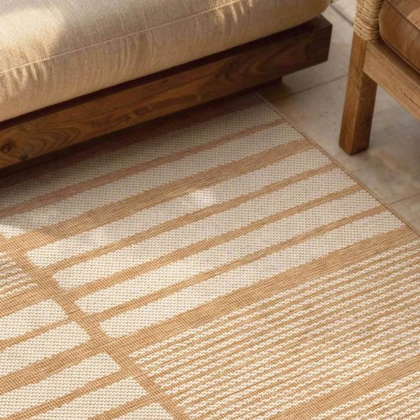 Close-up of a beige and white striped rug with wooden furniture in the background
