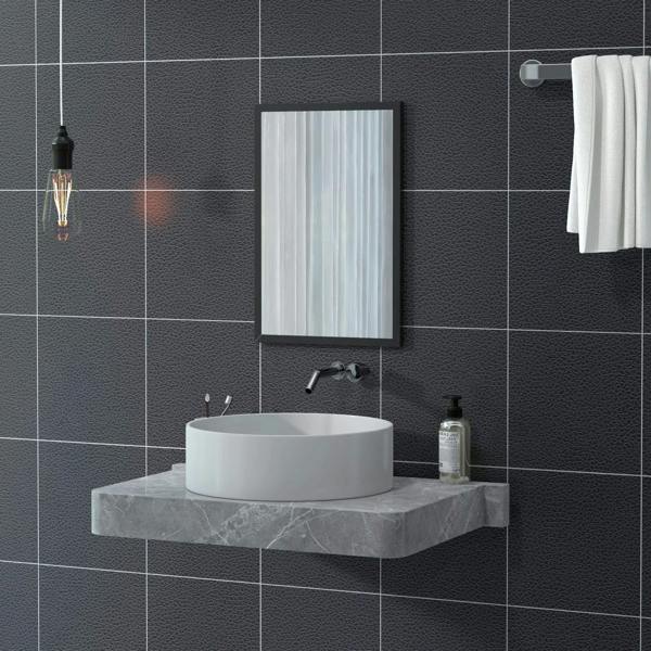 Black framed bathroom mirror on dark tile wall above a round sink