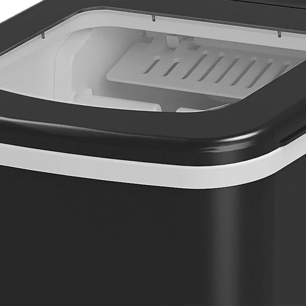 Black ice cube machine open ice bay with white plastic ice tray insert