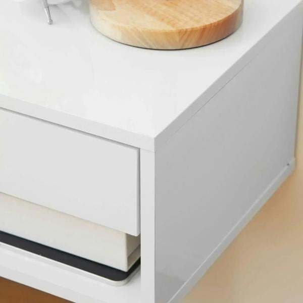 White floating bedside table side close-up with smooth drawer edge and open shelf