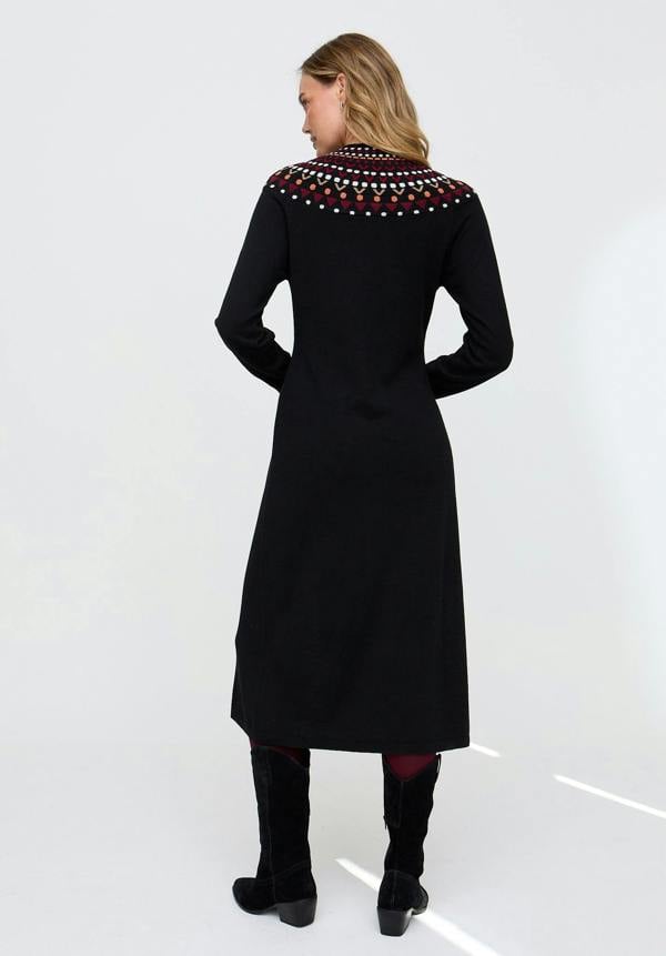 Woman wearing a black dress with colorful embroidery on a white background