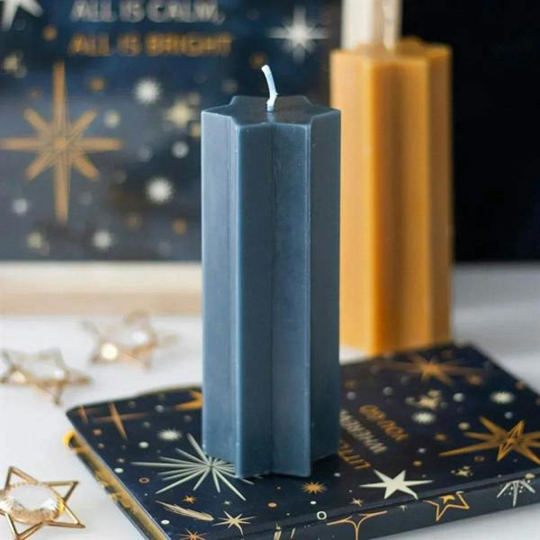 Navy star-shaped taper candle with blue wick and faceted body