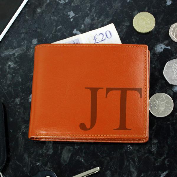 Tan leather wallet personalised with the initials "JT" in dark lettering, shown with a £20 note and coins.