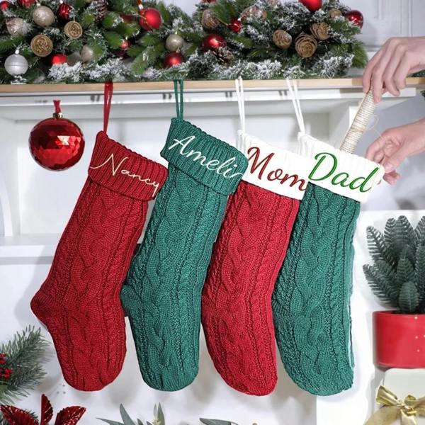 Four personalised embroidered cable-knit Christmas stockings named Nancy, Ameli, Mom, and Dad hanging on a mantelpiece