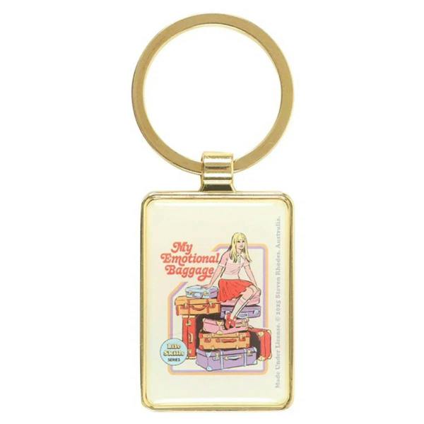 Gold keychain with square charm featuring an illustrated woman with suitcase labels.