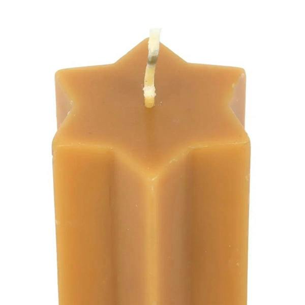 Close-up of gold star-shaped taper candle with wick