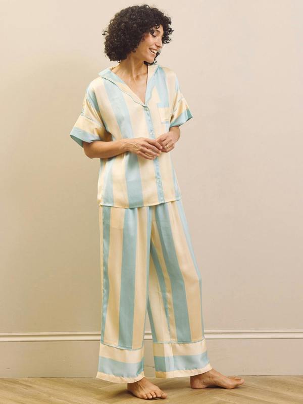 Woman wearing a striped pyjama set against a plain background
