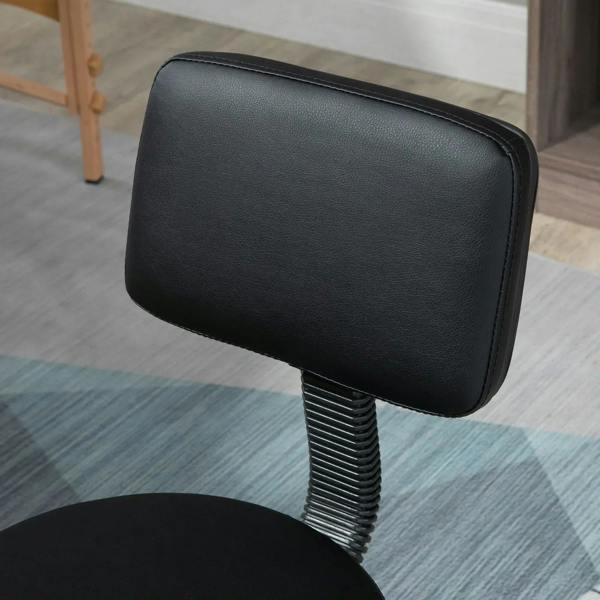 Black padded salon chair backrest with ribbed spring support and swivel base