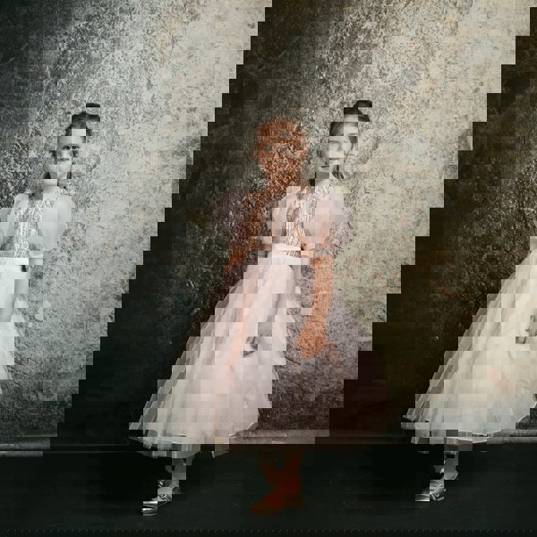 Dark haired girl wearing a blush coloured party dress from UK Flower Girl Boutique