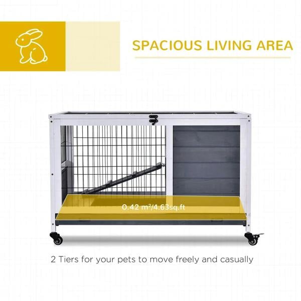 Grey wooden two-tier guinea pig hutch with wire gate and ramp inside enclosed area
