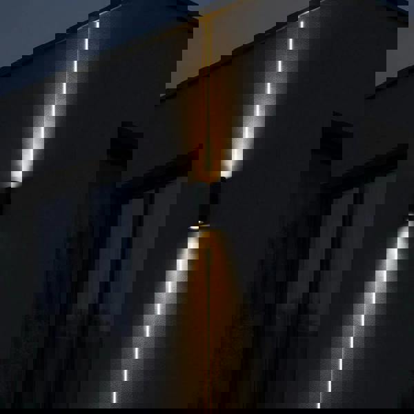 black up and down outside light mounted on a white wall on the exterior of a modern house 