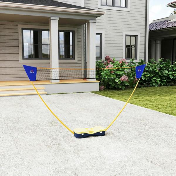 Outdoor folding badminton net set on concrete with yellow poles and blue corner flags