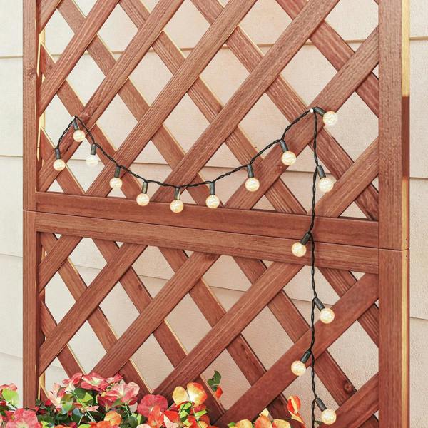 Wooden trellis panel for climbing plants with warm string lights, brown