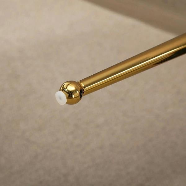 Close-up of gold metal chair leg with protective floor glides
