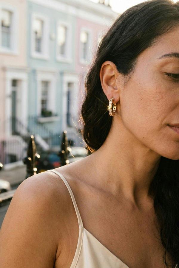 ARIIRA Lorelei Gold Tone Crystal Criss Cross Hoop Earrings