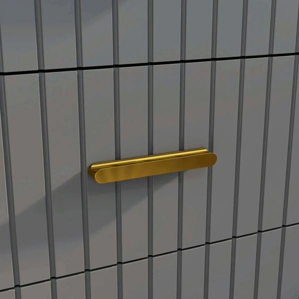 Gold-tone bar handle on a dark grey dresser drawer with embossed vertical line design