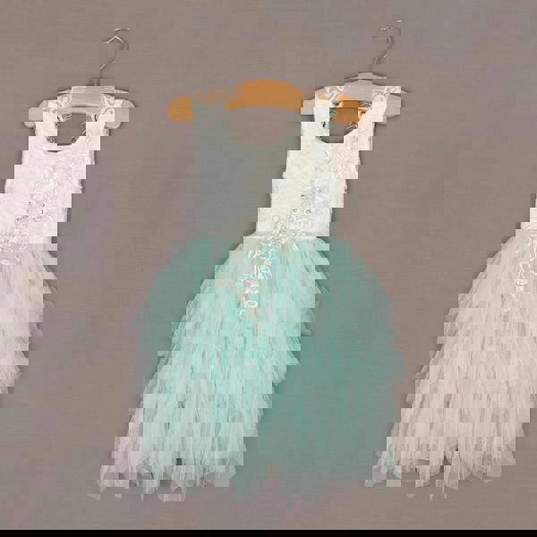 Children's dress with lace top and mint green skirt on a hanger against a brown background