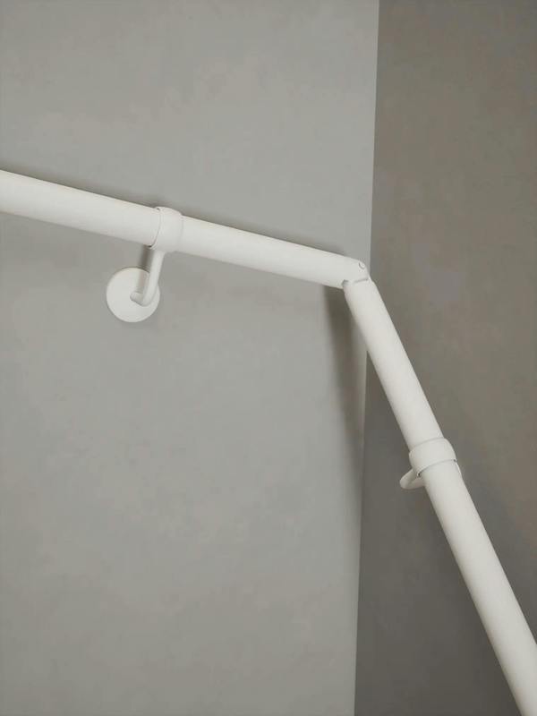 Matt white 40mm double winder handrail, close-up view of angled joint