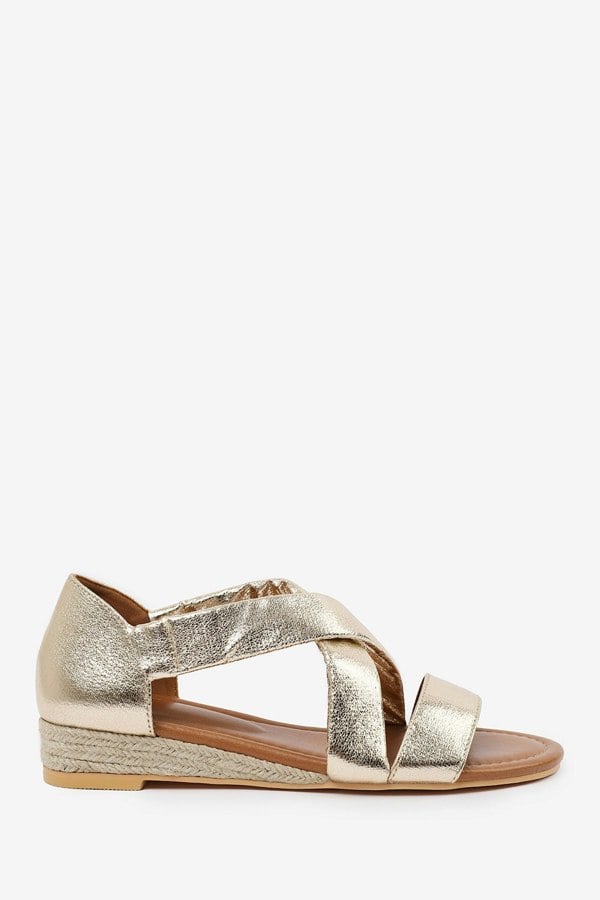 Where's That From Hummingbird Wide Fit Low Wedge Shoes With Cross Over Strap in Gold Metallic