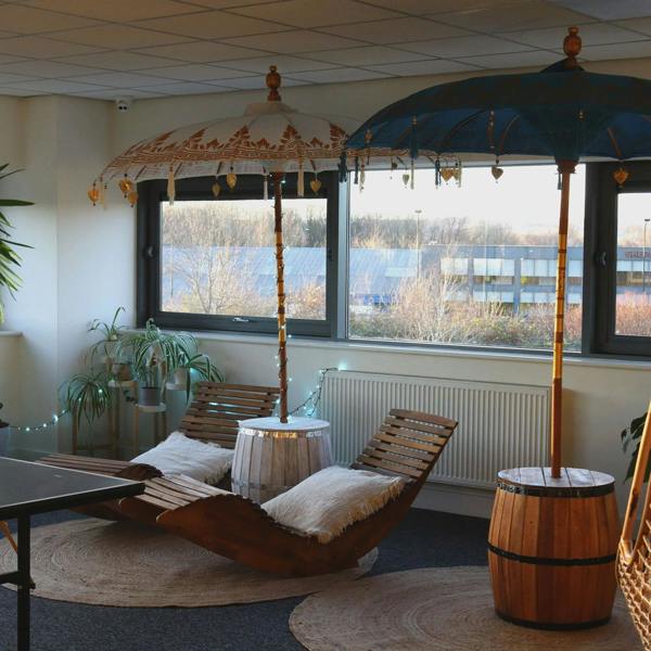 Natural wood barrel table and matching parasol stand in an indoor lounge setting