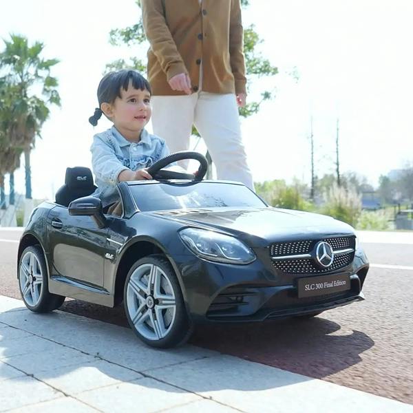 Black kids electric ride-on car with child seated and LED headlights on