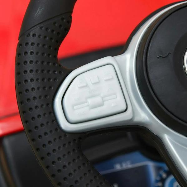Horn button and controls detail on red kids ride-on car steering wheel housing