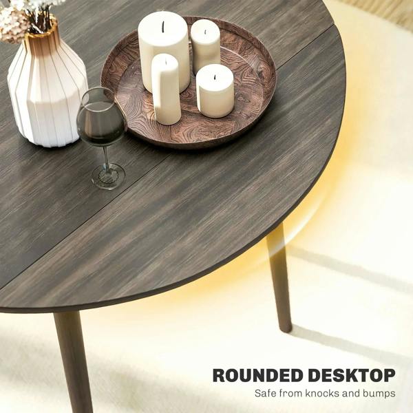 Grey round tabletop of a drop-leaf dining table with wood legs, candles on top